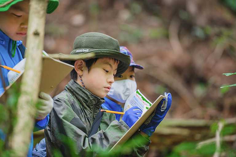 冒険の書にメモする子どもたち